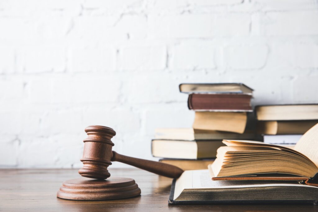 opened juridical books with gavel on wooden table, law concept